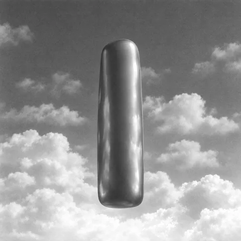 Ein aufrecht stehender, glänzender Monolith vor Wolken